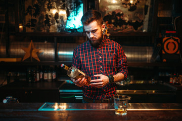 One man standing at the bar counter, drunkenness