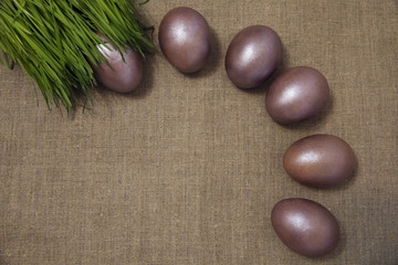 painted Easter eggs in the grass on the gray canvas