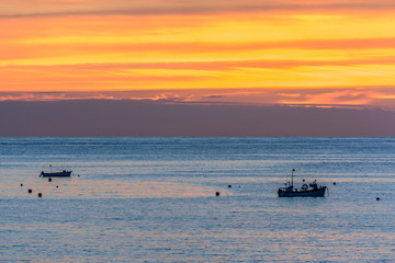 sunset with boats at the sea