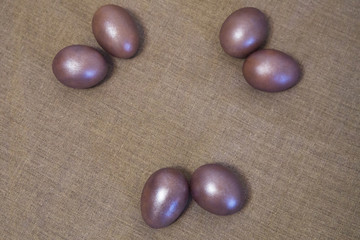 painted Easter eggs in the grass on the gray canvas background