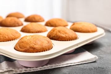 Baking tray with tasty cupcakes on table. Fresh from oven