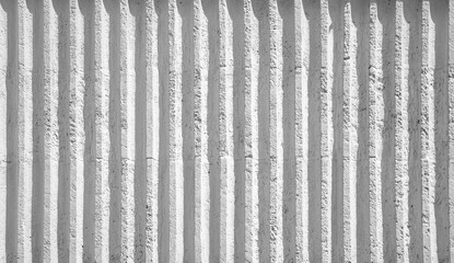 White ribbed concrete wall with shadows from the sun