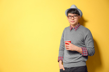 Portrait of handsome hipster in stylish outfit on color background