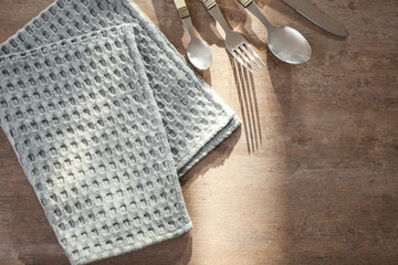 Clean kitchen towel and cutlery on table