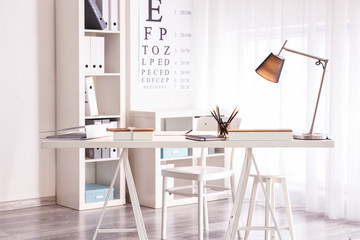 Comfortable workplace with modern lamp on table
