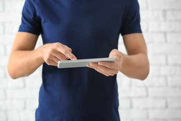 Man using tablet computer on light background