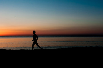 Silhouette of runner old man in the morning at the beach, sunrise Background.