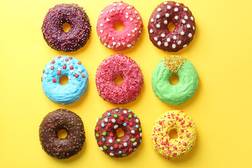Fototapeta na wymiar Delicious colorful donuts on color background