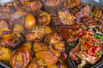 Fried pork knuckle and pork ribs on a cast-iron frying pan