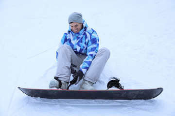Male snowboarder on ski piste at snowy resort. Winter vacation