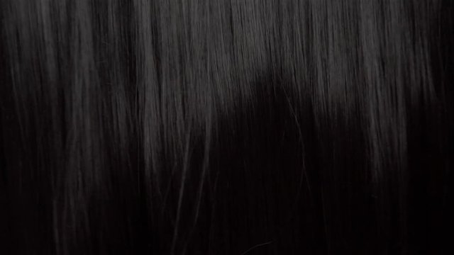 Hair texture background, no person. Black shiny hair curl falling down