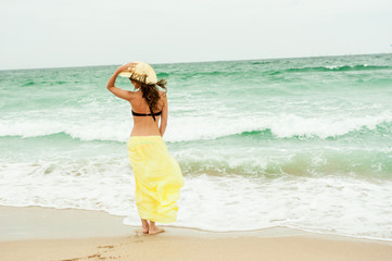 Romantic Beautiful girl in the yellow dress water beach