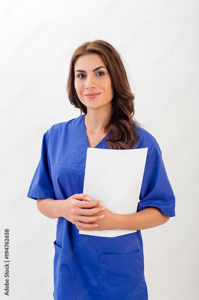 Wall mural smiling medical nurse in medical doctor uniform holding clipboard, isolated over white background.