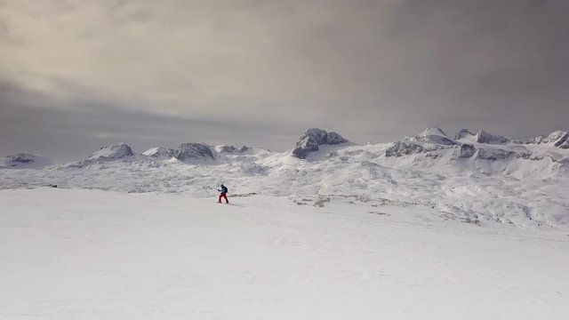 Young man climbing on ski in Alps, aerial footage of winter activity. 
