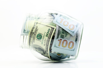 Dollars money in a glass jar on a white background