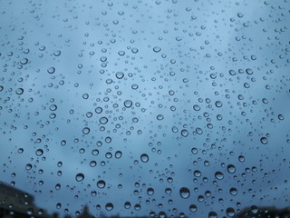 An amazing photography of the waterdrop effecton the window during the rain in winter in the city with some view to the outdoor 
