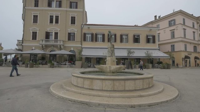 Round water fountain with statue in Rovinj