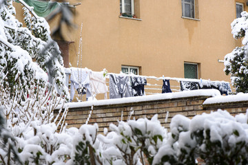 Drying clothes hanging on a clothesline in the winter on the garden near the house