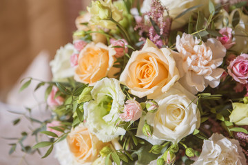 Wedding table decor full of rose and eustoma flowers, candles and peach colored fabric. Luxury rich restaurant interior. Indoor. Copy space