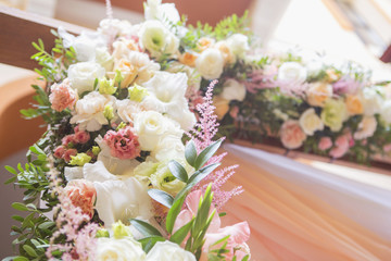 Wedding arch decor full of rose and eustoma flowers, candles and peach colored fabric. Luxury rich restaurant interior. Indoor. Copy space