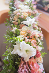 Wedding arch decor full of rose and eustoma flowers, candles and peach colored fabric. Luxury rich restaurant interior. Indoor. Copy space