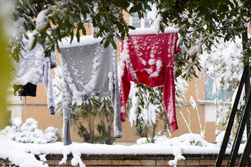 Drying clothes hanging on a clothesline in the winter on the garden near the house