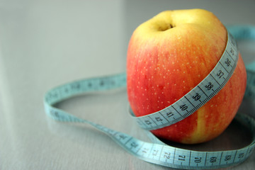 Apple and ribbon on the table (diet and healthy food)