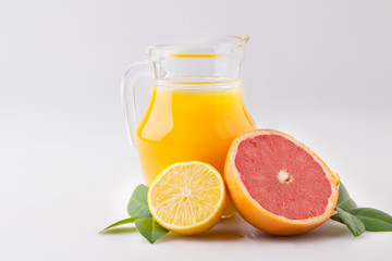 Fresh orange juice and citrus fruits lime lemon grapefruit in a jar white background healthy concept