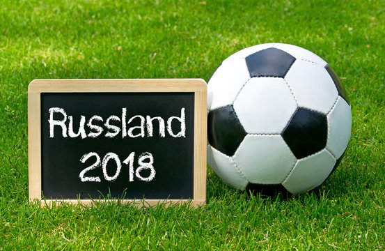 Russland 2018 - Fußball mit Kreidetafel und Text auf Spielfeld mit grünem Rasen