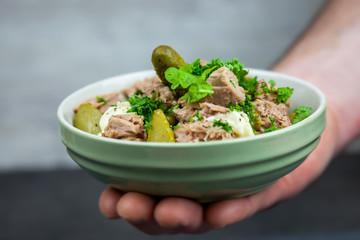 Tuna salad with cucumber, green peas, parsley and dill in the bowl