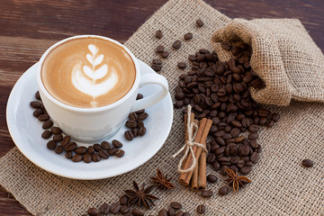 A cup of latte coffee and coffee beans.