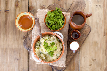 Mashed potatoes with basil and fresh parsley. Lunch in the style of a duck. Ceramic ware. Wooden background. Healthy eating.