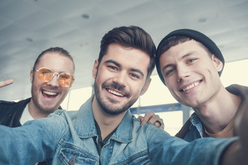 Portrait of happy comrades looking at camera indoor. Entertainment concept