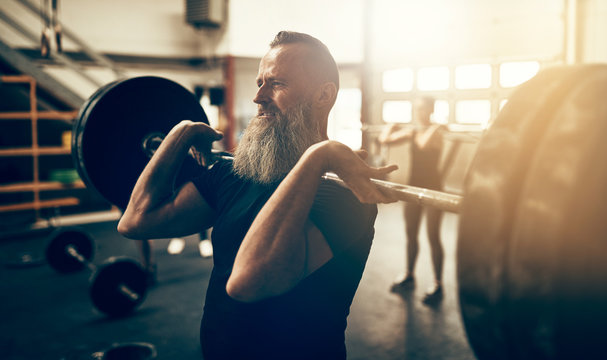 Mature Man Working Out With Weights In A Gym