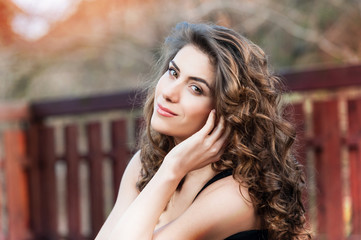 Young woman outdoors portrait. Soft sunny colors on a summer sunny day.