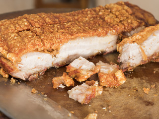 Crispy pork large sheets on the chopping board cut into pieces