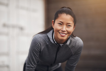 Fit young Asian woman in sportswear out for a run