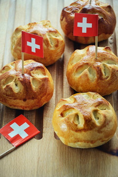 Celebrating Switzerland National Day on August 1st with traditional symbols like swiss flag red with white cross. Special bread buns with cross shape cut. Red berry sauce with  white cross.