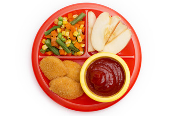 Children's Plate with a Well Balanced Meal of Chicken Nuggets, Vegetables and Sliced Apple