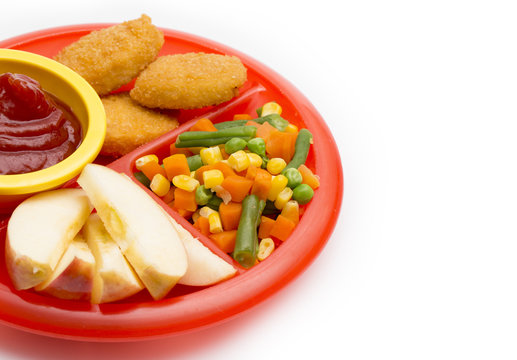 Children's Plate With A Well Balanced Meal Of Chicken Nuggets, Vegetables And Sliced Apple