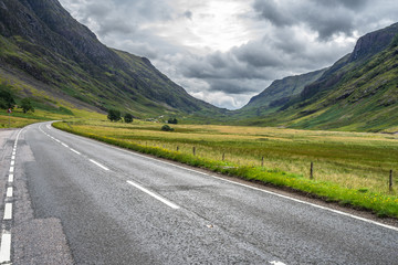 Scenic road in Glencoe valley with dramatic cloudy sky, Highlands, Scotland, Britain