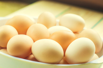 white and brown fresh chicken eggs in a plate. concept of easter. cooking ingredients