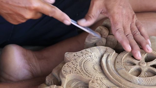 Indonesian man makes wooden souvenirs for tourists. Ubud, island Bali, Indonesia. Close up