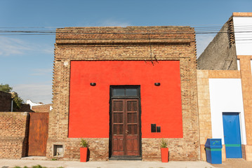 Casa antigua de color rojo y ladrillos de barro