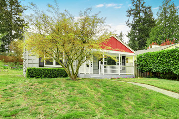 Charming home exterior with green siding and red covered porch.