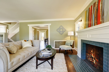 Chic green living room with a traditional fireplace.