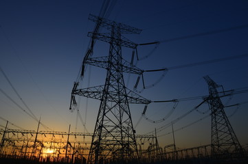 The silhouette of the evening electricity transmission pylon