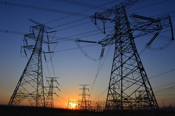 The silhouette of the evening electricity transmission pylon