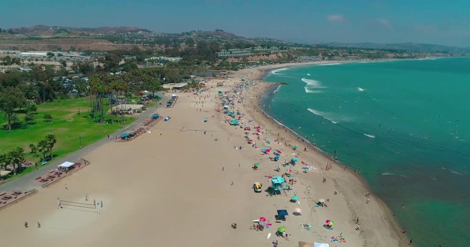 DANA POINT, California. Doheny State Beach. A sunny day beach scene with people engaged in beach activities. Surfers. Aeria 4K