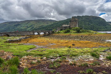 Fototapeta premium Dramatic cloudy landscape with Eilean Donan castle, a famous landmark in Scottish Highlands, Scotland, Britain